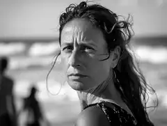 Schwarzweißes Porträt einer Frau am Strand.